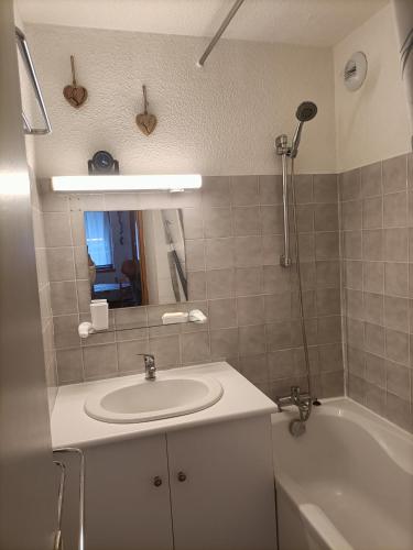 une salle de bain avec un lavabo, une baignoire et un miroir dans l'établissement Appartement 5 pers Plagne village, à La Plagne