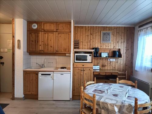 a kitchen with a table and a kitchen with wooden cabinets at Au Bord des Pistes in La Plagne