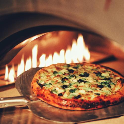 a pizza is being cooked in an oven at Courtyard by Marriott Navi Mumbai in Navi Mumbai