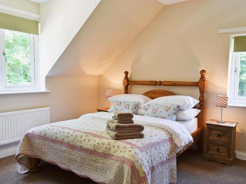 a bedroom with a bed and two windows at Baswick Steer in Burshill