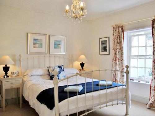 a bedroom with a bed and a chandelier at Solent Cottage - Pqqu in Yarmouth