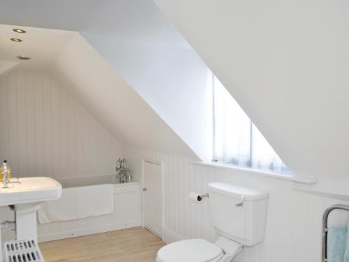 a white bathroom with a toilet and a sink at Solent Cottage - Pqqu in Yarmouth