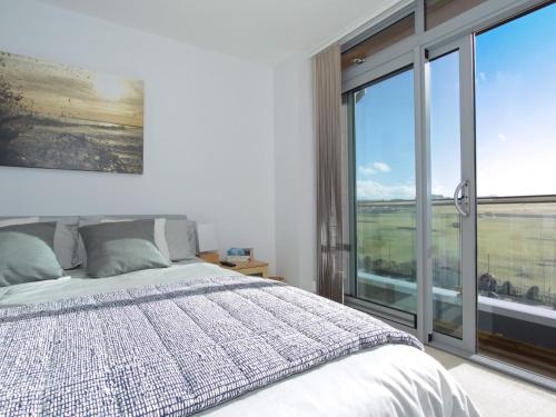 ein Schlafzimmer mit einem Bett und einem großen Fenster in der Unterkunft 7 Cribbar in Newquay