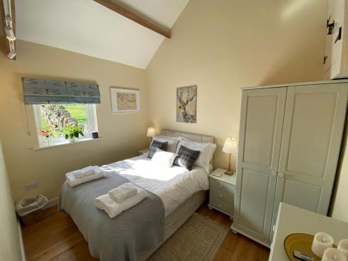 a bedroom with a bed with two towels on it at Mark Close Milking Parlour in Alston