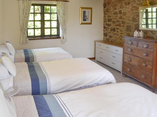um quarto com 2 camas e uma cómoda em The Garden Room - 15536 em Marldon