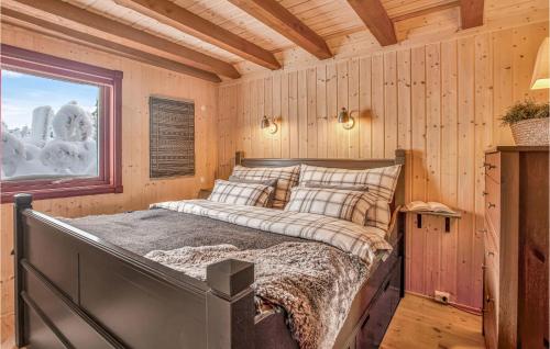 een bed in een houten kamer met een raam bij Nice Home In Reinli With Kitchen in Reinli