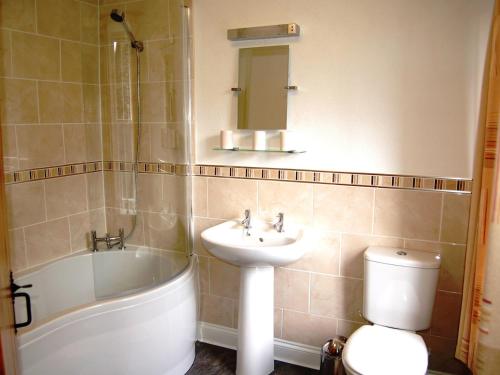 a bathroom with a sink and a tub and a toilet at Alvamere in Keswick