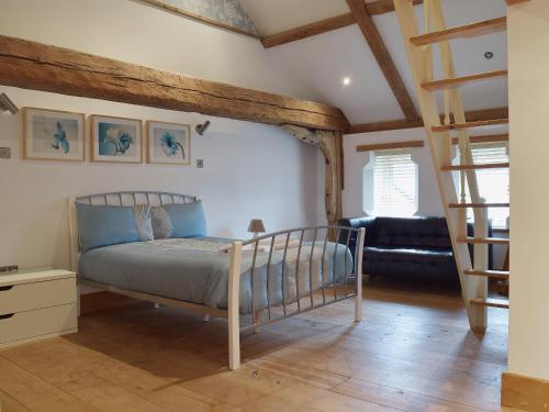 a bedroom with a bed and a living room at Hobland Barn in Belton