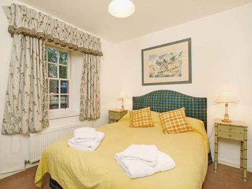 a bedroom with a bed with two towels on it at Stables Cottage-uud in Corsock