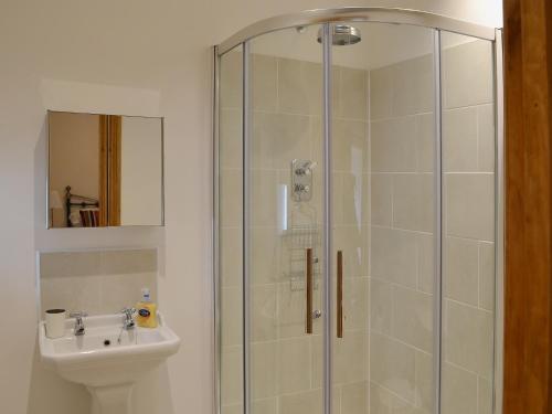 a bathroom with a shower and a sink at The Byres in Greenhaugh