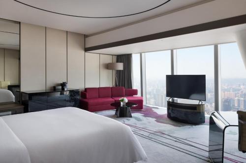 um quarto de hotel com uma cama e uma televisão em Four Seasons Hotel Guangzhou-Free Shuttle Bus to Canton Fair Complex & Overseas Buyer Registration Services during Canton Fair Period em Guangzhou