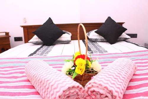 a bed with two pillows and a basket of flowers on it at Hispaniola villa in Mirissa
