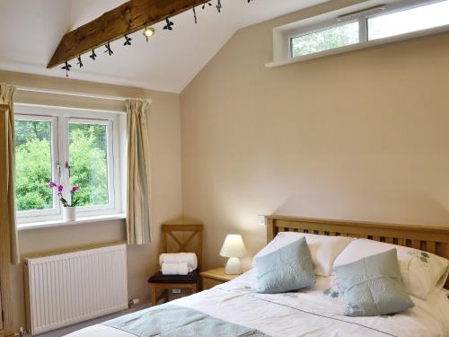 a bedroom with a bed and a window at Dairy Cottage in Bodmin