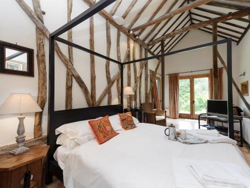 a bedroom with a white bed in a room with wooden beams at Thatched Cottage in Saxmundham