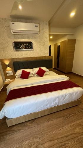 een slaapkamer met een groot bed met rode kussens bij KVP GOLDEN INN in Tirupati