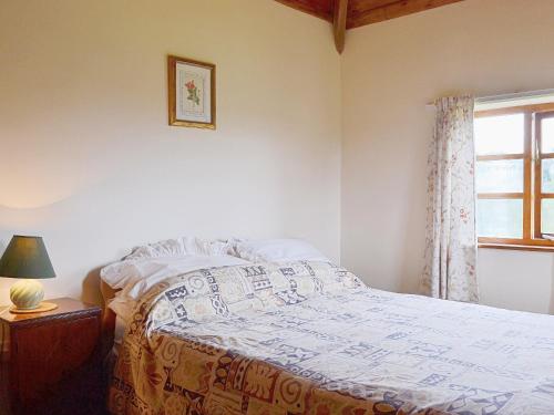 a bedroom with a bed and a window at The Oast House in Boraston