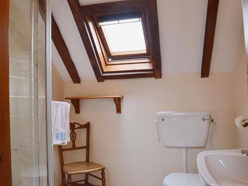 a bathroom with a toilet and a skylight at The Oast House in Boraston