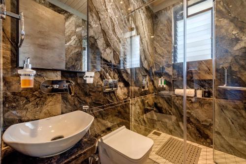La salle de bains est pourvue d'un lavabo et d'une douche. dans l'établissement SaffronStays HeavOne Penta, Lonavala, à Lonavala