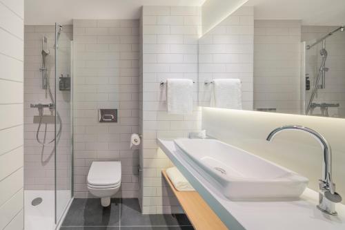 a bathroom with a sink and a toilet and a shower at Holiday Inn Express - Marne-la-Vallée Val d'Europe, an IHG Hotel in Bailly-Romainvilliers