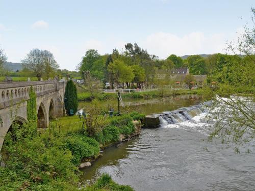 een brug over een rivier met een waterval bij Strawberry Lodge in Cheddar