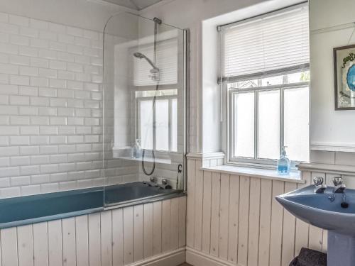 y baño con ducha, bañera y lavamanos. en Yew Tree Cottage, en Windermere