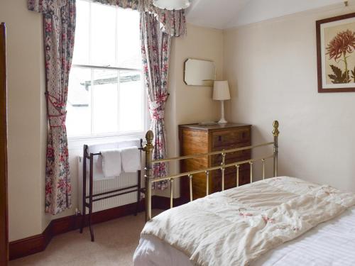 1 dormitorio con cama y ventana en Yew Tree Cottage, en Windermere