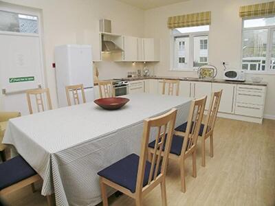 een keuken met een witte tafel met stoelen en een kom erop bij The Gatehouse in Hooke