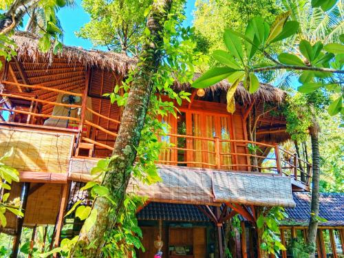 a bamboo house with a tree at Dreamy Eco Tree House by 7 Waterfalls in Ambengan