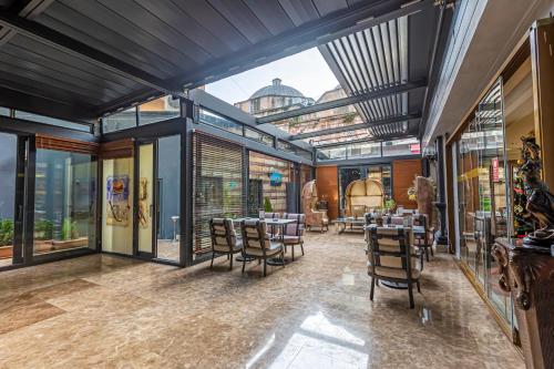 een eetkamer met tafels en stoelen en grote ramen bij Eurostars Hotel Old City in Istanbul