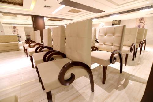 a row of white chairs in a room at Udman Hotel Haridwar in Haridwār
