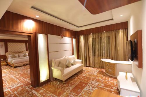 a living room with a couch and a television at Udman Hotel Haridwar in Haridwār