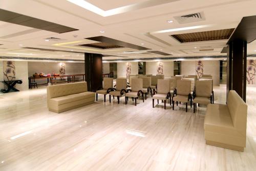 a salon with chairs and tables in a room at Udman Hotel Haridwar in Haridwār