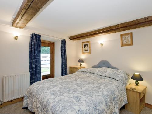 a bedroom with a bed and a window at Malt Shovel in Dilham