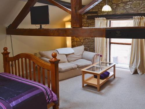 a living room with a bed and a couch at The Stables in Ball