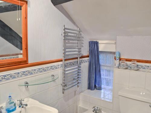 a bathroom with a sink and a toilet and a mirror at Toms Cottage in Dalton in Furness