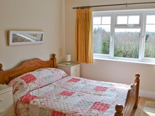 een slaapkamer met een bed en een raam bij Heron Cottage in Timsbury