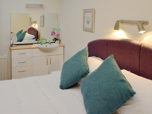 - une chambre avec un lit avec deux oreillers et un lavabo dans l'établissement Little Beeches, à Grasmere