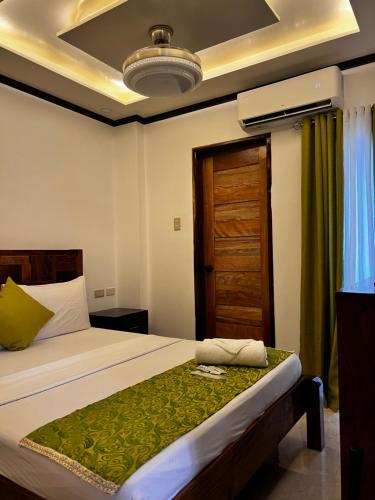 a bedroom with a bed and a wooden door at Aquilah Homestay Inn in Coron
