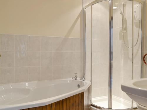 a bathroom with a shower and a tub and a sink at The Gingang -24969 in Frosterley