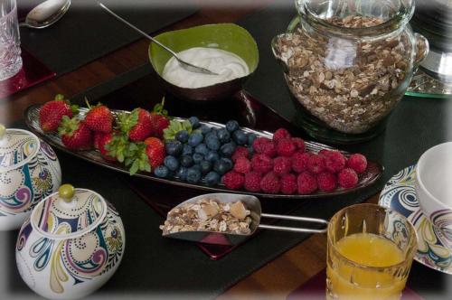 a table with a plate of fruit and yogurt at Tregondale Manor Farm in Liskeard
