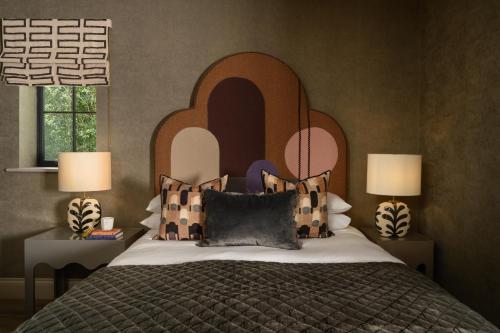 a bedroom with a bed with a headboard and two lamps at The Tempus at Charlton Hall Estate in Alnwick
