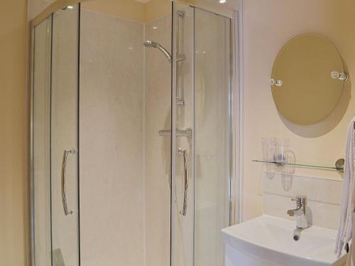 a shower with a glass door next to a sink at The Parlour in Normanton on Trent