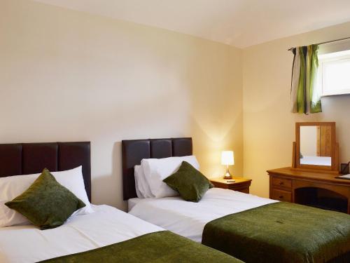 a hotel room with two beds and a mirror at The Parlour in Normanton on Trent