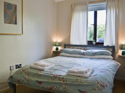 1 dormitorio con 1 cama con toallas en Sailfish, en Benllech