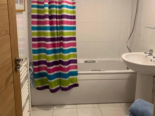 baño con cortina de ducha colorida y lavamanos en Sailfish, en Benllech