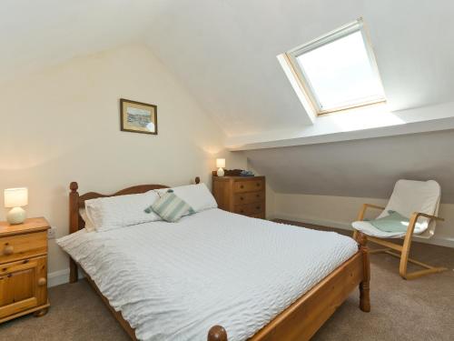 a bedroom with a bed and a window and a chair at Tinakori in Staithes