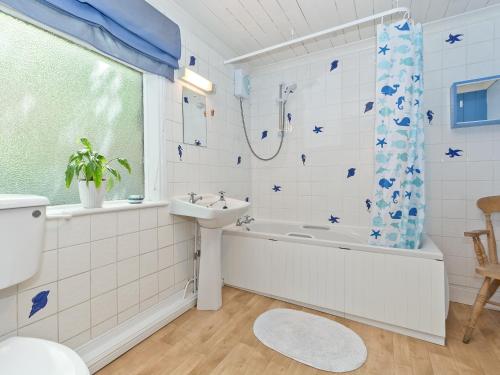 a bathroom with a tub and a sink and a toilet at Tinakori in Staithes