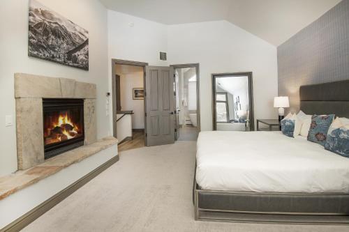 een slaapkamer met een bed en een open haard bij Ski In Ski Out Rocky Mountain Townhome in Beaver Creek
