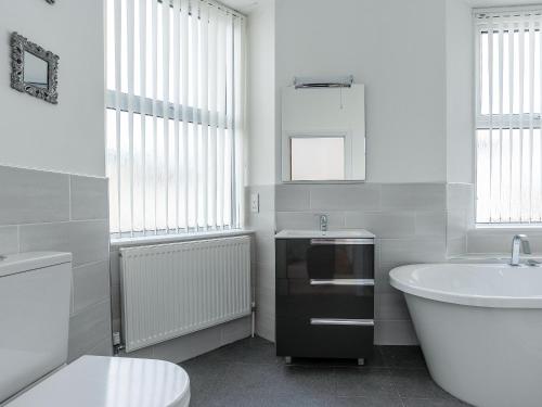 a bathroom with a tub and a sink and a toilet at Babbacombe Bay, Torquay in Torquay