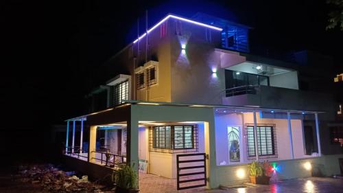 a house lit up at night with purple lights at Kappys Villa in Igatpuri